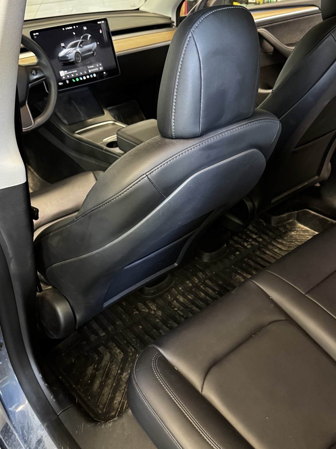Before photo of a dirty rear passenger area in a Tesla